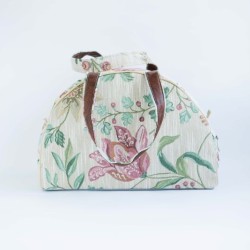 Dekoratiivse lillemusriga pastellsetes toonides kangast reisikott.