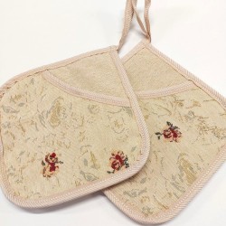 Heledal põhjal kireva väikese lillemustriga taskuga pajalapid.