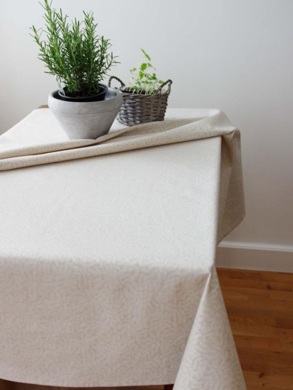 Peene valge taimeoksa mustriga tumebeežil põhjal laudlina.