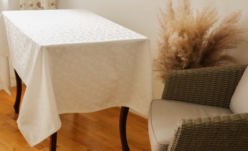 Pidulik õrna taimemustriga laudlina.